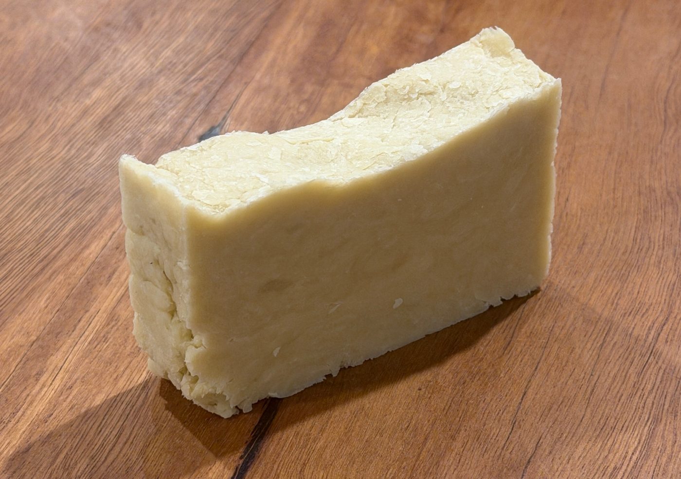 A bar of Pure by Dr Kynan shower soap on a wooden surface